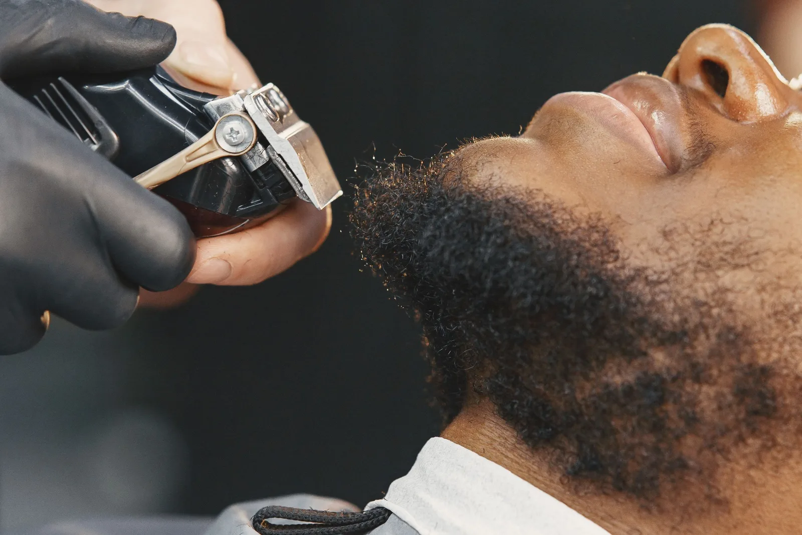 A beard being trimmed with clippers