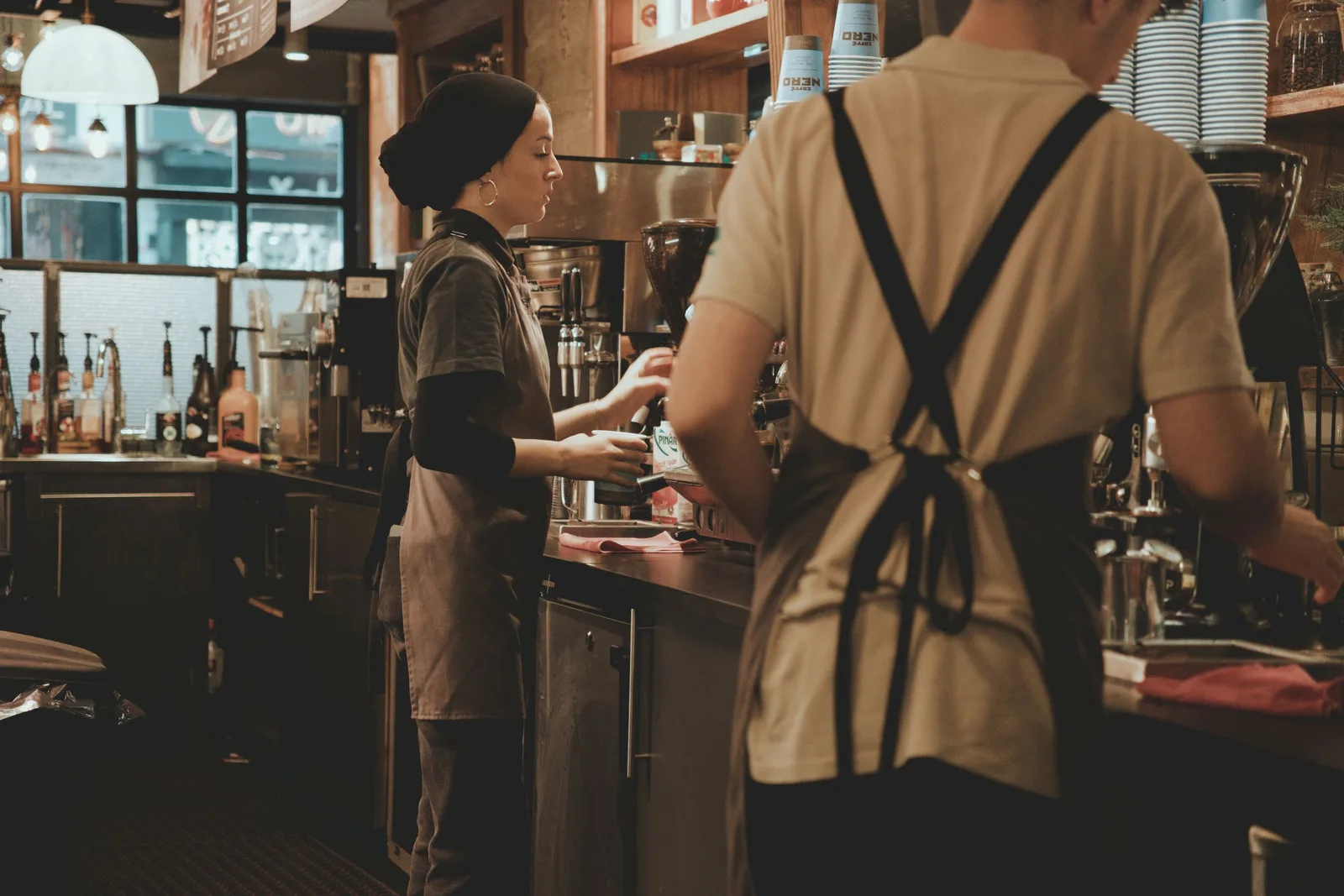 Baristas behind a warm wooden counter