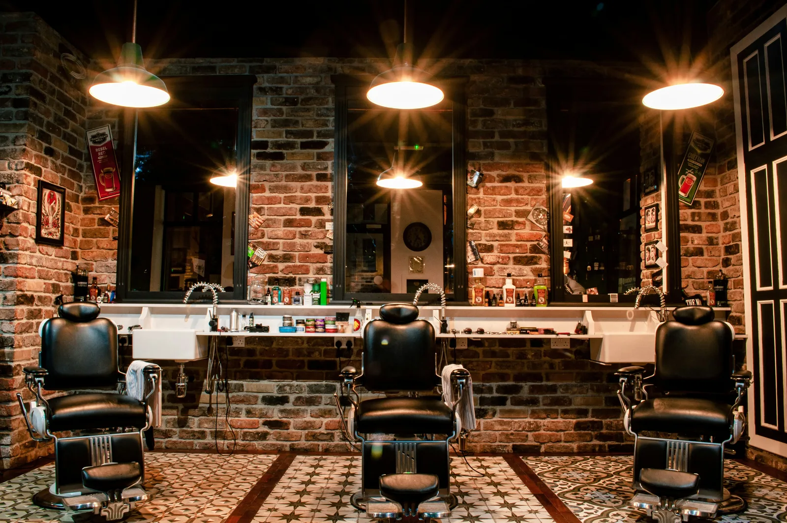Leather barber chairs against a brick wall