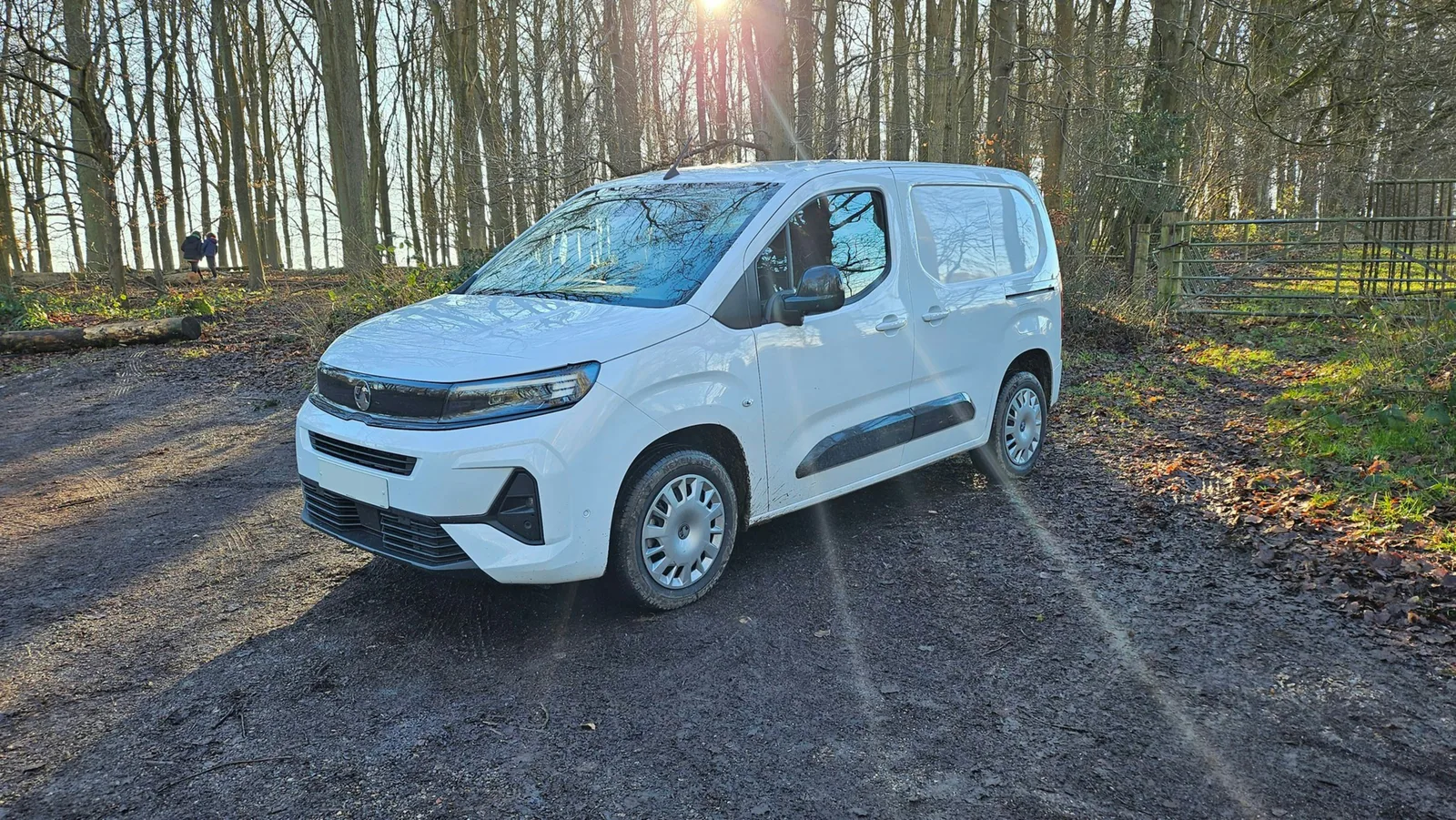 A white work van parked on a forest track